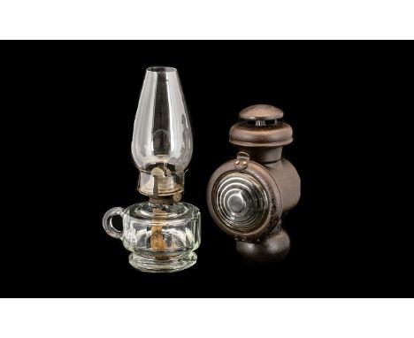 Two Oil Lamps to include a clear faceted Queen Anne oil lamp and a Railway lamp. 11 and 9 inches in height.