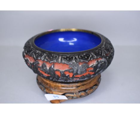 A Cinnabar lacquer Japanese bowl decorated with mythical landscape on blue enamel base with carved stand