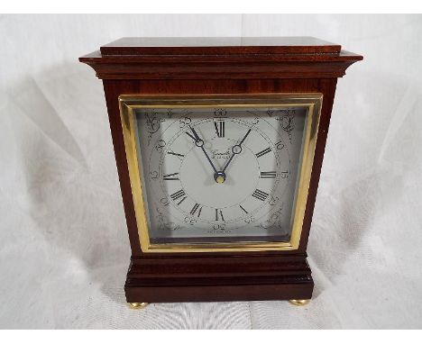 A good mahogany mantel clock by Comitti of London, square white dial with brass bezel, on brass bun feet Est £30 - £50