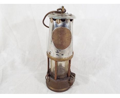 A miner's brass safety lamp marked Protector Lamp & Lighting Type GR6S 38 Eccles, approximately 24cm (h)