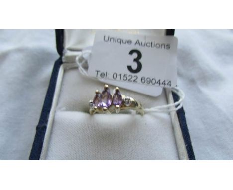 A three stone 9ct gold diamond and amethyst ring, size O.  