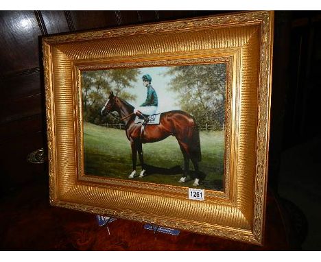 A gilt framed print of a racehorse.  
