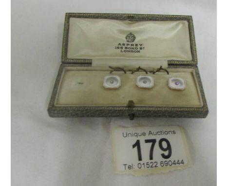 An Asprey set of three studs (one missing) in mother of pearl with centre diamond, platimum surround, gold backs, in fitted b