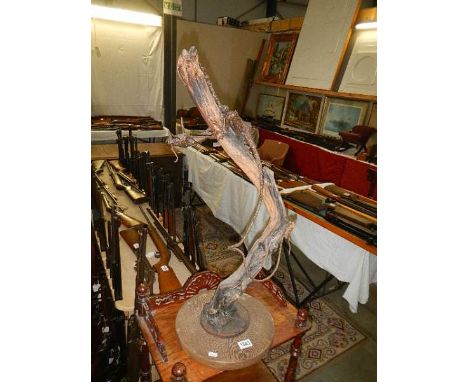 An unusual sculpture of a dragon climbing a tree in bronzed metal.  Collect only.  