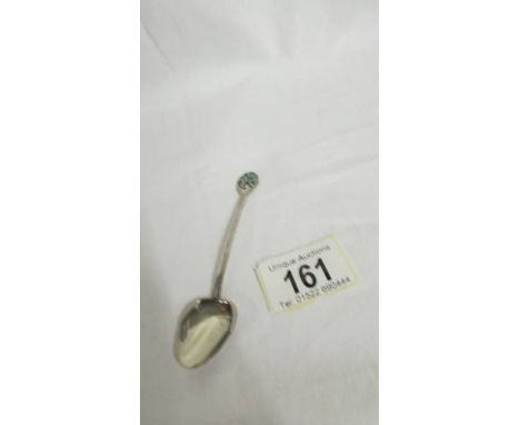 A Liberty and Co., Cymric silver spoon with enamelled flower finial, circa 1905.  