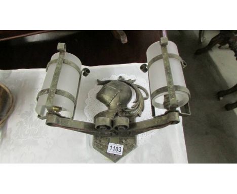 A double metal wall light depicting a knight's head.  