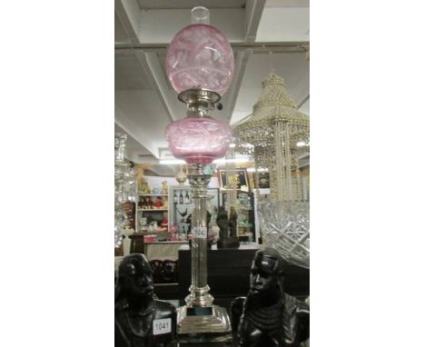 A silver plated Corinthian column oil lamp with pink glass font and shade.  Collect only.*CONDITION REPORT*Height 81cm to top