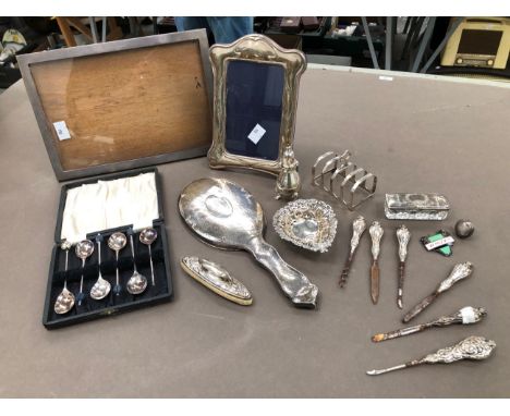 TWO HALLMARKED SILVER PHOTO FRAMES, A DRESSING MIRROR, TOAST RACK, A PIN TRAY, A BALUSTER PEPPER ETC. 