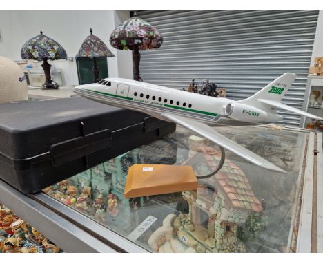 A SCALE MODEL FALCON 2000 JET AEROPLANE WITH A STAND AND PACKING CASE