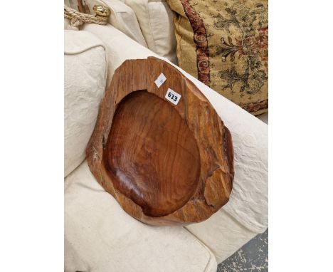 A SHALLOW BOWL CARVED FROM A TREE TRUNK