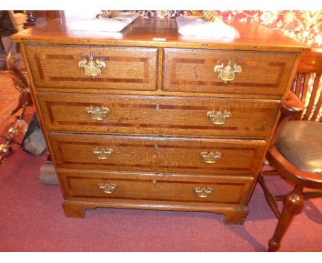 A Georgian oak and crossbanded chest fitted two short and three long drawers on brass handles on bracket feet