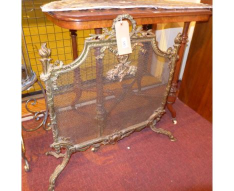 A 19th century French gilt brass firescreen, the mesh guard with applied ribbon and foliate motifs on leaf decorated scroll f