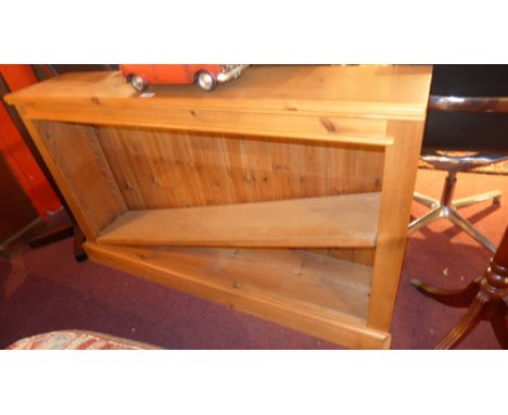 A pair of contemporary pine bookcases each with a single adjustable shelf, raised on a plinth base