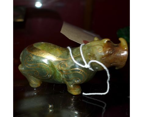 A Chinese jade figure of a mythical beast with inlaid gilt metal detail 