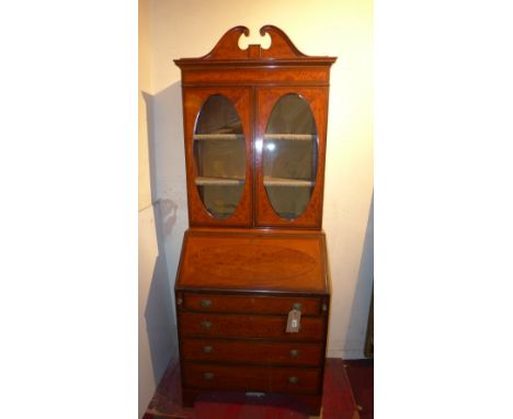 An Edwardian Satinwood and inlaid Sheraton revival bureau bookcase, the swan neck pediment over two over glazed doors above f