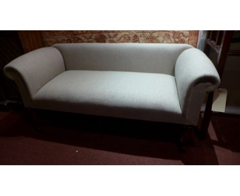 A contemporary designer sofa of smaller proportions upholstered in beige linen raised on turned supports  