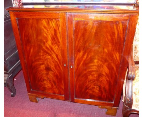 A mahogany dwarf two door cabinet on bracket feet