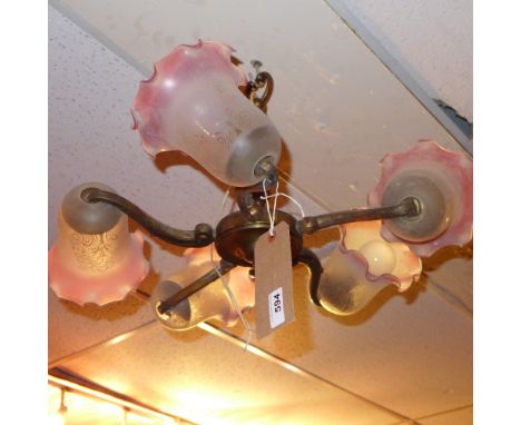 A vintage brass five branch chandelier having frosted glass shades