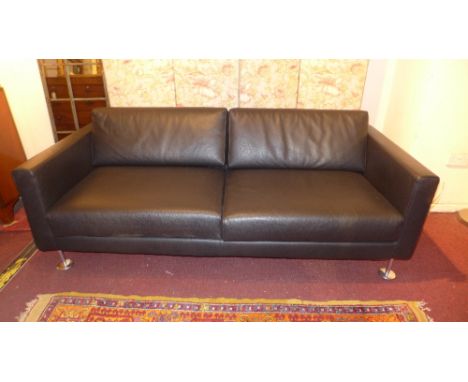 A contemporary designer three seater sofa, by Vitra, the black leather upholstery raised on polished chrome slender supports