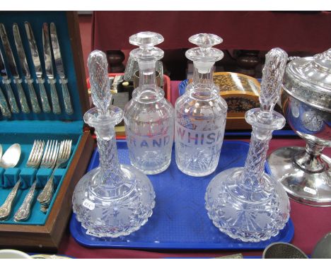 A Pair of "Whiskey" and "Brandy" Decanters, with etched labels surrounded by scrolling vines, a pair of similarly attached wi