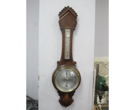 An Early XX Century Oak Two Dial Aneroid Barometer, with a temperature gauge, silver dial.