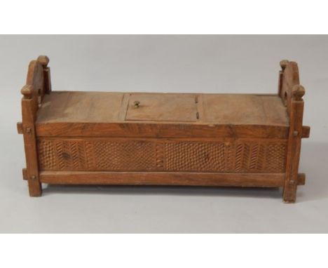 An Indonesian hardwood low carved marriage chest, with hinged lid to the top and carved fish scale designs to the panel sides