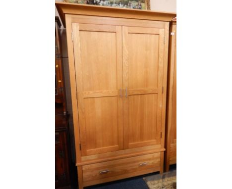 A modern light oak hanging wardrobe, with plain cornice and enclosed by two panelled doors with drawer below, 121cm wide x 19