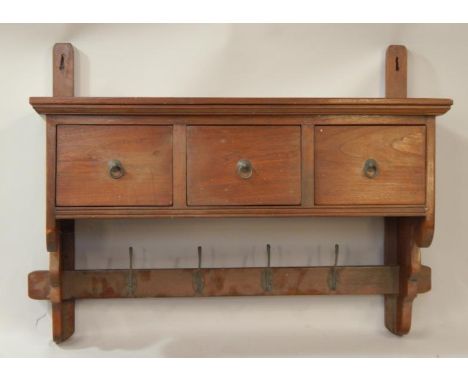 A hanging shelf bracket, fitted with three drawers, coat hooks below, 97cm wide.