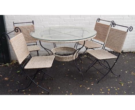 A modern dining room suite, comprising of a circular dining table with iron frame and woven rush surround and plate glass top