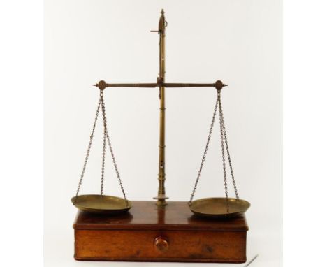 A set of 19thC Avery counter top balance scales, on a mahogany stand fitted with a drawer and two sets of brass weights and o