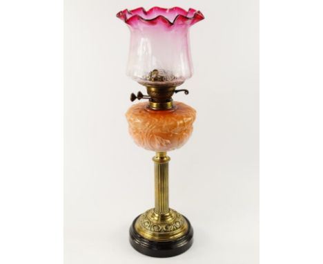 A Victorian brass oil lamp, with duplex burner, reeded column and supporting a glass reservoir with moulded foliate designs i