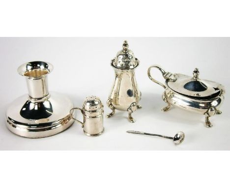 A small group of silver items, including drum mustard, two pepper pots and a plated candlestick.