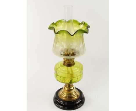 A Victorian brass oil lamp, with duplex burner and green clear glass reservoir and green graduated tinted shade with acid etc
