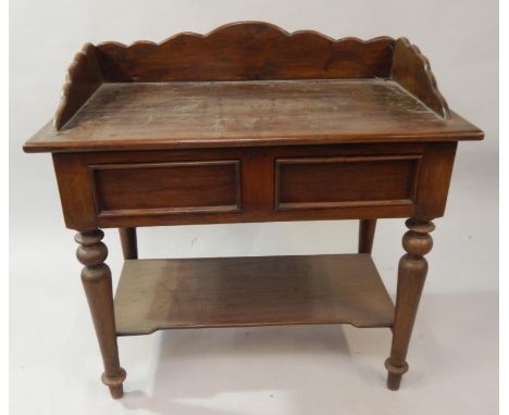 A dark hardwood side table, with shaped gallery surround and fitted with two frieze drawers, on turned and tapered legs, with