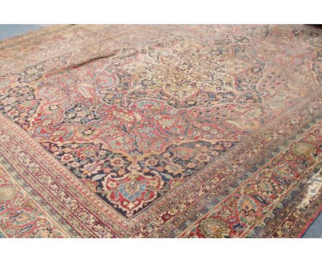 A 19thC Persian bordered carpet, with central stylized floral medallion and floral motifs and sprigs in blue and cream on a r