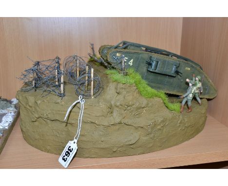 A DIORAMA OF A MK1 TANK CROSSING BARBED WIRE, approximate 1/32 scale, constructed plastic kit on a  polystyrene base, has bee