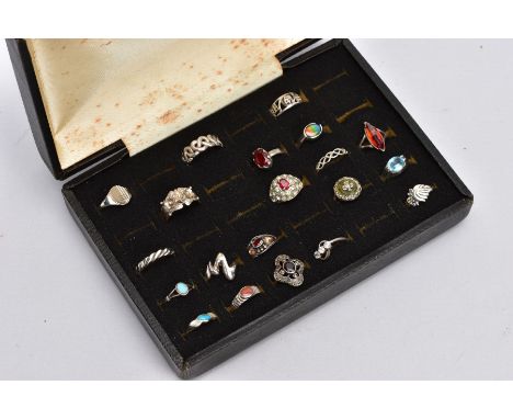 A RING STORAGE BOX WITH RINGS, to include twenty white metal rings in total, such as a Celtic band, a garnet set ring with ro