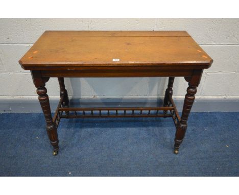 AN EDWARDIAN WALNUT CARD TABLE, with a fold over top enclosing a baize interior, on turned legs united by a single spindles s