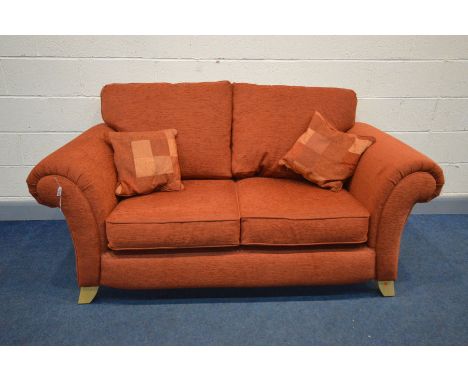 A BURNT ORANGE SETTEE, inner width 120cm, on splayed feet