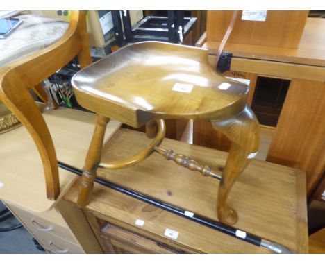A TWENTIETH CENTURY MILKING STOOL AND A METAL MOUNTED WALKING STICK WITH HORSEHEAD MOUNT 