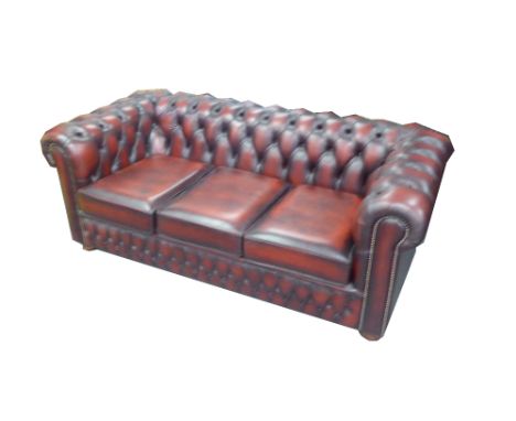 CHESTERFIELD ROUND BACKED THREE SEATER SETTEE, BUTTON UPHOLSTERED IN ANTIQUED CRIMSON HIDE 