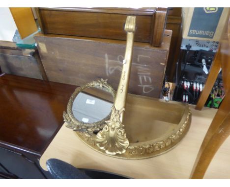 A GILT CONSOL PATTERN WALL BRACKET AND A SMALL GILT FRAMED OVAL WALL MIRROR