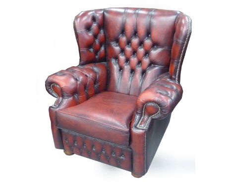 A WINGED LOUNGE CHAIR, BUTTON HOLSTERED IN ANTIQUES CRIMSON HIDE 