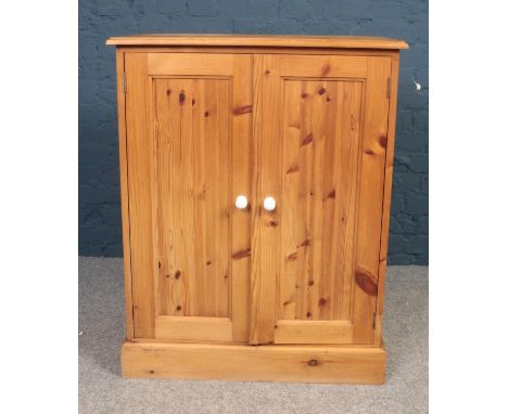 A large Pine two door cupboard with fitted shelving. H: 96cm, W:77cm, D: 45.5cm.  Condition good. Will need a hinge on one of