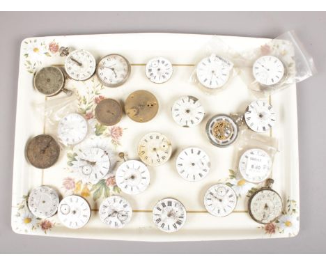 A tray of pocket watch movements, mostly with enamel dials.  