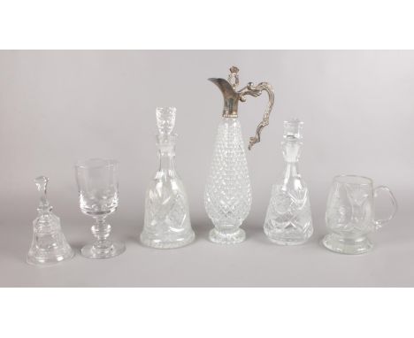 A group of glassware - to include an unmarked white metal mounted glass claret jug with stopper, two cut glass decanters and 