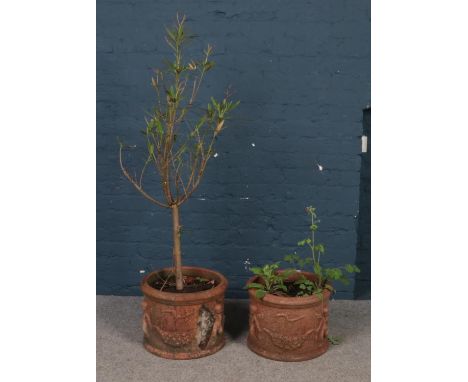 A pair of terracotta garden planters. With cherub decoration. (height 31cm, diameter 41cm).  One with damage to side.