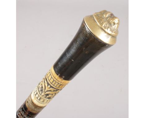 A Victorian ebonised walking stick. With brass lion mask pommel.  