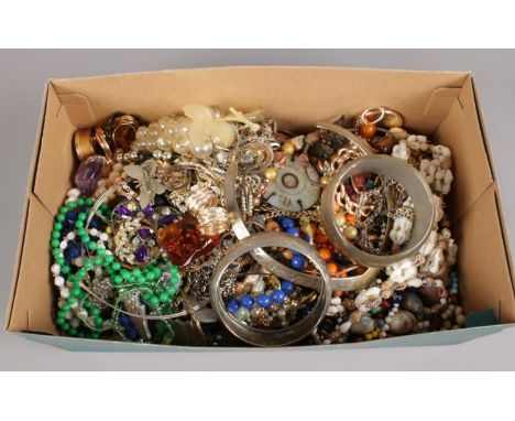 A box of costume jewellery. Includes shell necklace, white metal bangle, beads etc.  