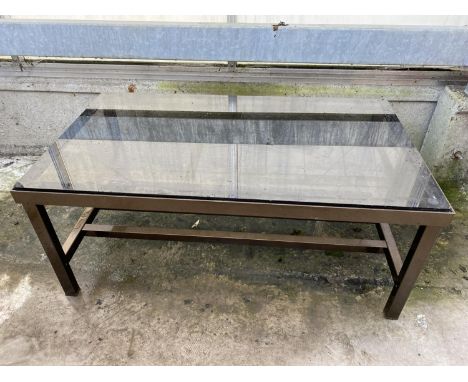 A MODERN METAL FRAMED COFFEE TABLE WITH SMOKED GLASS TOP AND MAGAZINE SHELF, 35.5 X 20.5" 